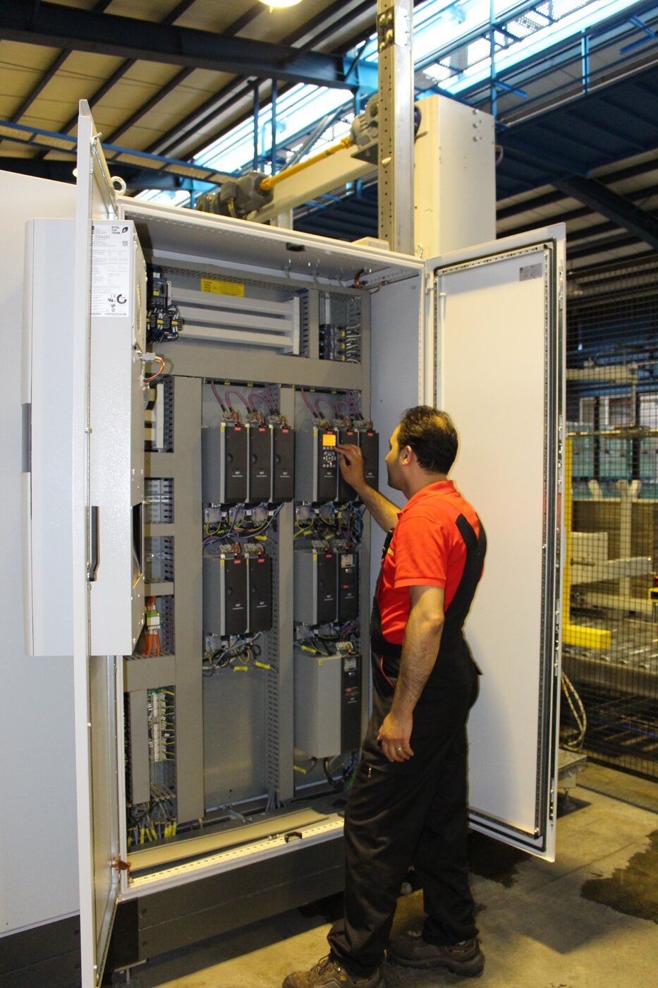 Ebrahim Mohammadpour working beside an industrial electrical control panel